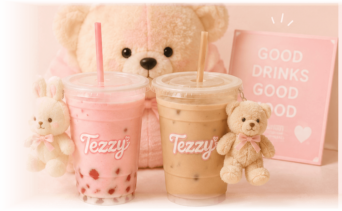 A strawberry milkshake and an iced latte from Tezzy, each with a plush bear or bunny clipped to the cup, in front of a large pink teddy bear